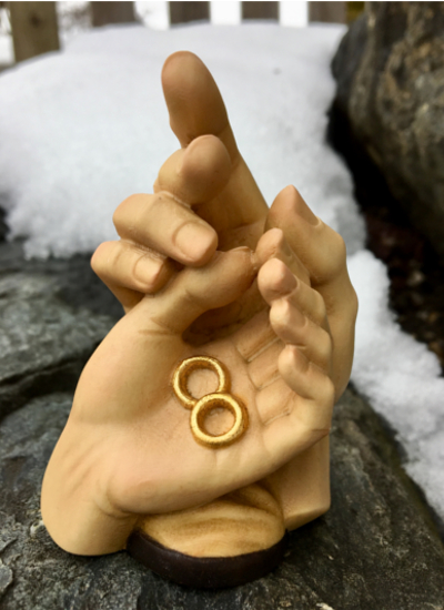 Geborgenheit der Ehe, geschnitzte Hände mit Ringen aus Holz